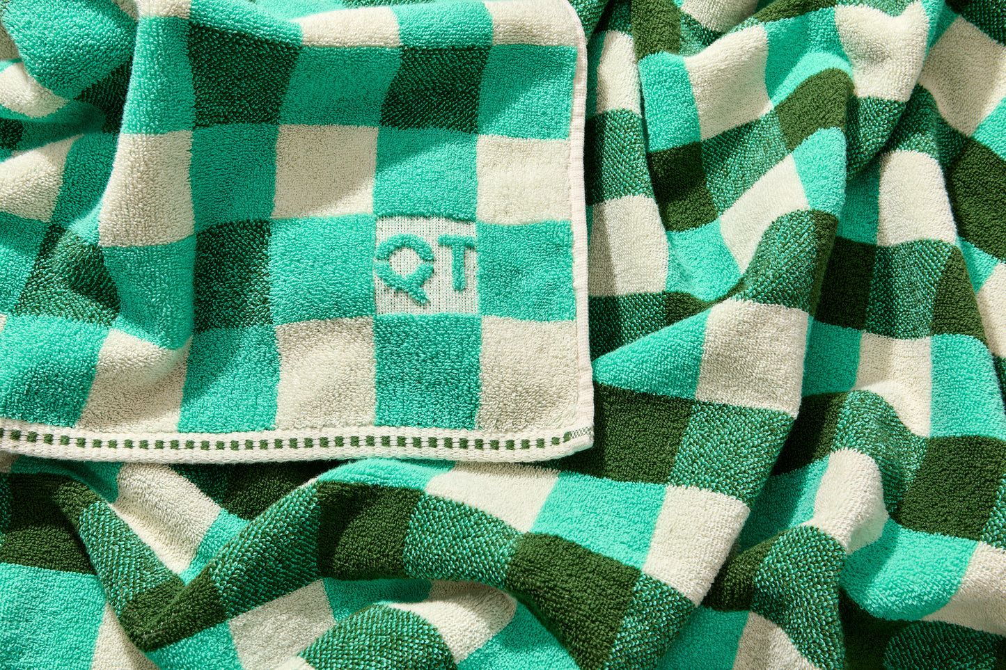 Tam bath sheet in pine with embossed QT logo on the corner.