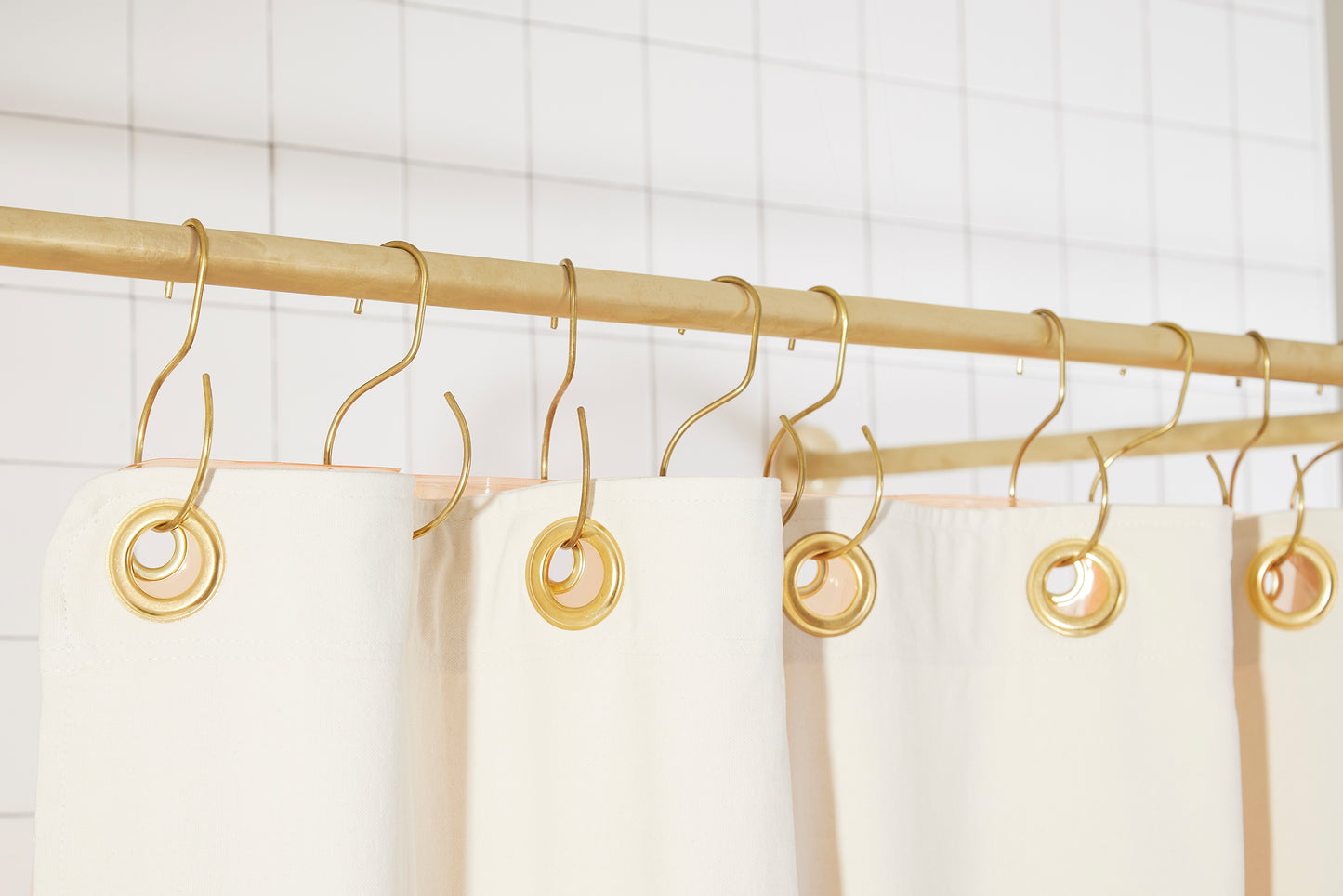 Orient Night Ride detail view of grommets and hooks hanging from shower curtain rod.