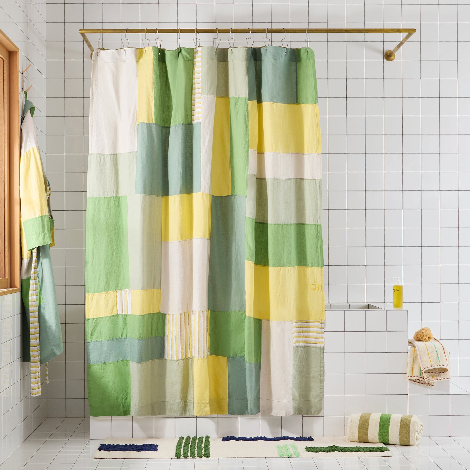 Green and yellow checkered shower curtain in a bathroom setting with matching bath mats.