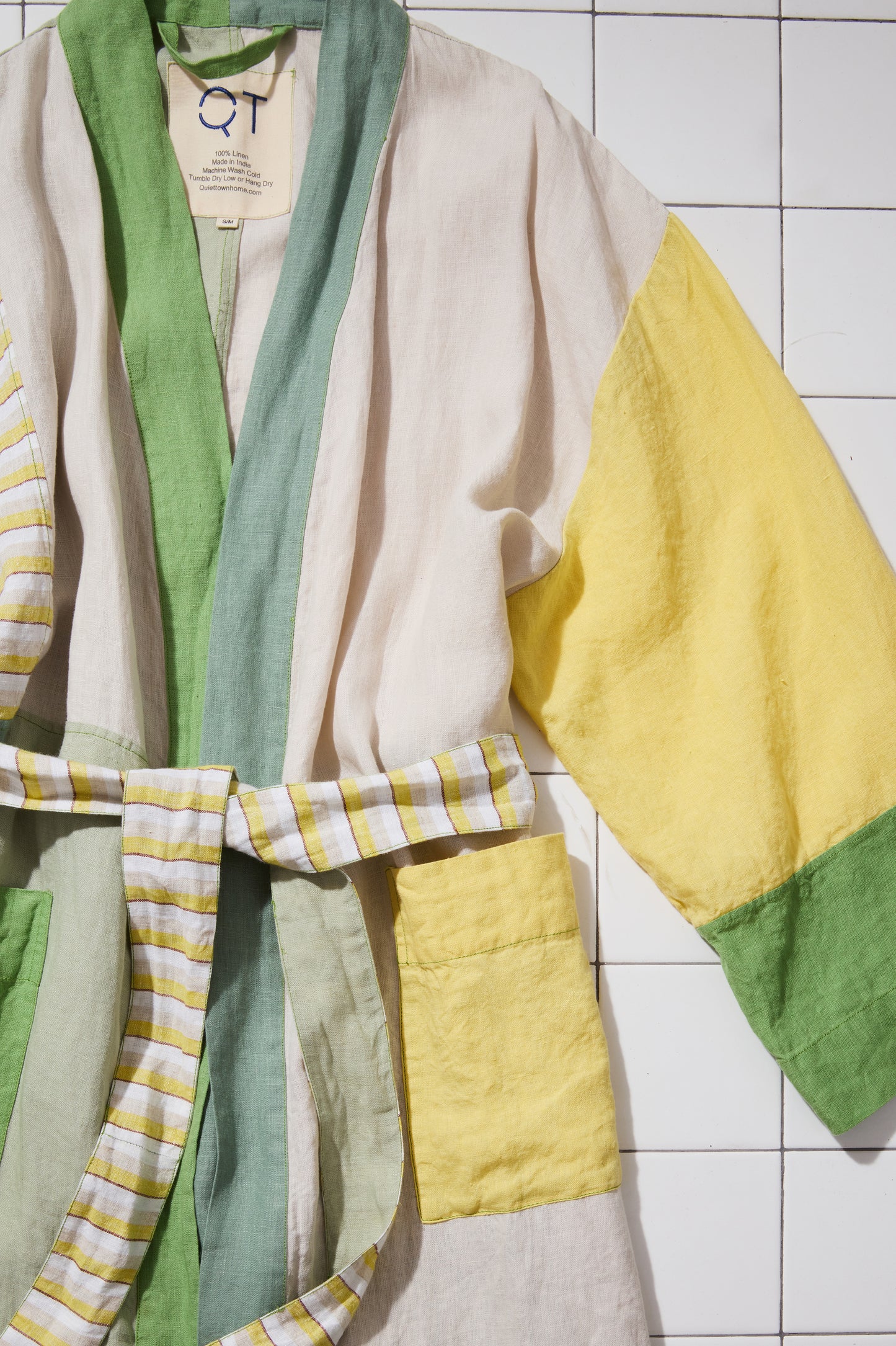 Cropped-in Color-blocked green and yellow robe on tiled floor. 