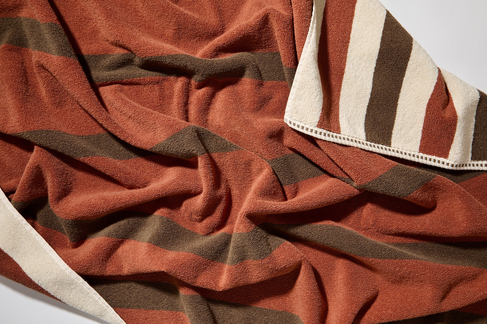 Close up of catalina bath sheet in chocolate, double sided with color to color stripes and a cream stripe running through the other side. 